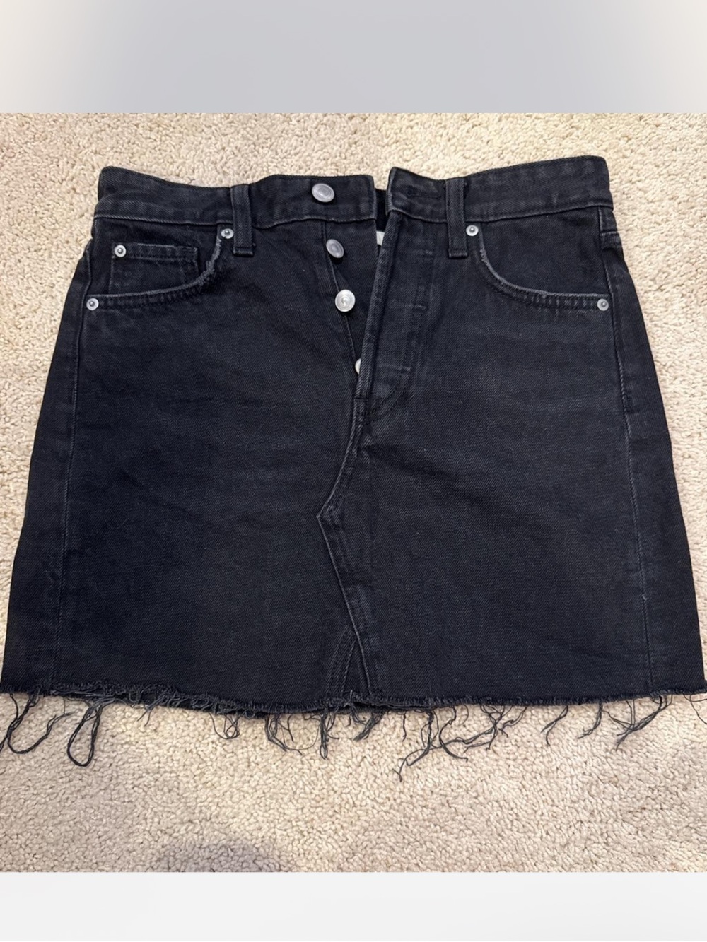 Black denim mini skirt with frayed hem. Size US 4.